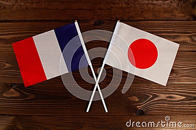 Flag of France and flag of Japan crossed with each other. The image illustrates the relationship between countries Stock Photo