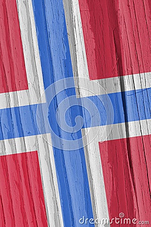 The flag of Norway on a dry wooden surface, cracked with age. Light pale faded paint. Patriotic background or wallpaper. Stock Photo