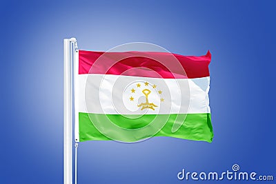 Flag of Tajikistan flying against a blue sky Stock Photo