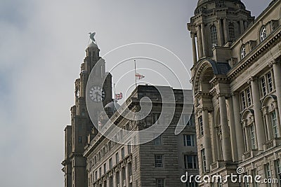 Flag of UK and England flew at half-staff on a building at Liverpool waterfront Stock Photo