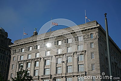 Flag of UK and England flew at half-staff on a building at Liverpool waterfront Stock Photo