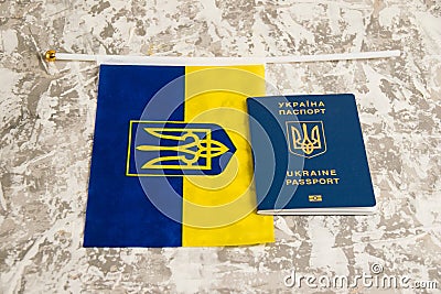 Ukraine, Chernihiv, July 5, 2023: Flag of Ukraine with coat of arms and passport of citizen of Ukraine on light gray Editorial Stock Photo