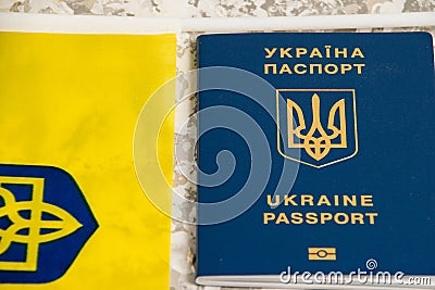 Ukraine, Chernihiv, July 5, 2023: Flag of Ukraine with coat of arms and passport of citizen of Ukraine on light gray Editorial Stock Photo