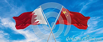 flags of China and Bahrain waving in the wind on flagpoles against sky with clouds on sunny day. Symbolizing relationship, dialog Stock Photo