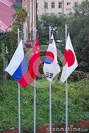 Flags of Japan, Russia, China, Republic of Korea on the flagpoles Editorial Stock Photo
