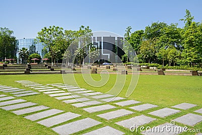 Flagstone pavements in lawn before modern buildings on sunny sum Stock Photo