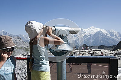 Cute little braided haired girl look Mont Blanc with binoculars Editorial Stock Photo