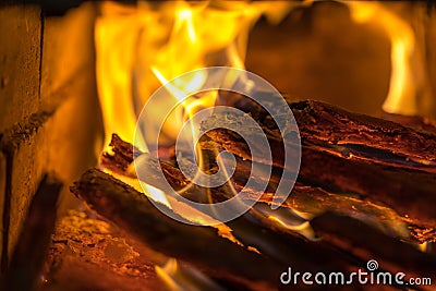 Flame incinerates firewood and transforms it ashes, close up, shallow depth of field. Blaze in a large stove. Nature Stock Photo