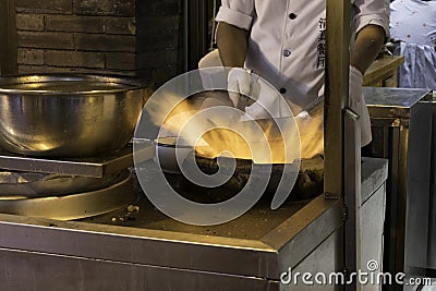 Fire and Food a chinese chef prepares food in a wok Stock Photo