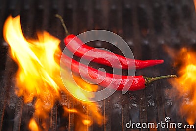 Flaming hot chilli peppers on bbq grill Stock Photo