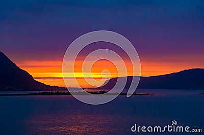 Colorful midsummer sky in orange, yellow and violet at Norwegian Sea, North Norway, Flaming sunset. Stock Photo