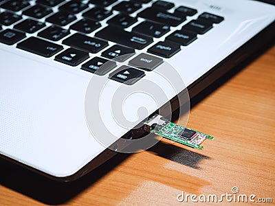 A flash drive that is in an incomplete condition plugged into the laptop Stock Photo