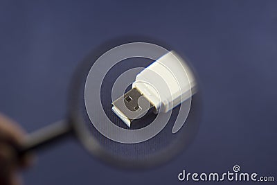 Flash drive under magnification through magnifier, blue background magnifier Stock Photo