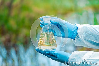 A flask with water from a lake in the hands of a environmentalist chemist Stock Photo