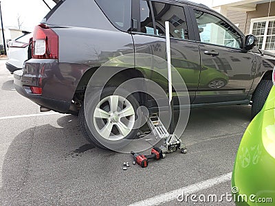Flat Changed To Spare Tire In Parking Lot Stock Photo