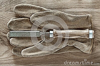 Flat chisel leather safety gloves on wooden board Stock Photo