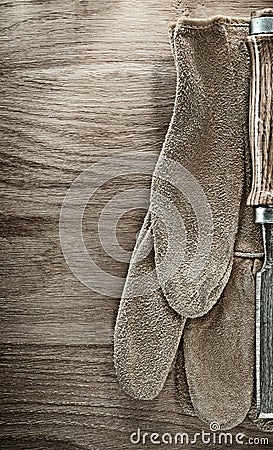 Flat chisel protective gloves on wooden board Stock Photo