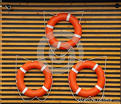 Flat closeup of three red lifebuoys wall on white Stock Photo
