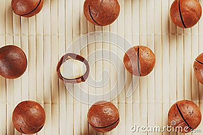 Flat composition with Australian macadamia nuts on bamboo light background. Patterns, repetitions Stock Photo