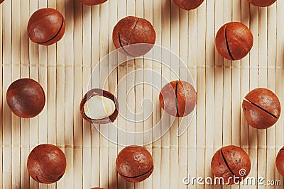 Flat composition with Australian macadamia nuts on bamboo light background. Patterns, repetitions Stock Photo