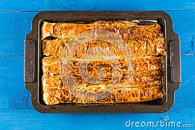 Flat lay above homemade domestic crisp pie above blue wooden planks background Stock Photo