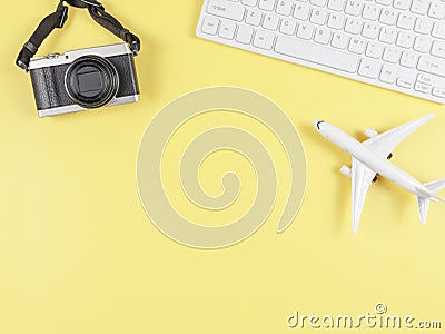 flat lay of airplane model, computer keyboard, and digital camera with copy space on yellow background, business and traveling Stock Photo