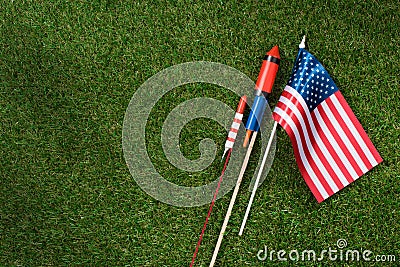 flat lay with american flagpole and fireworks on green grass, americas independence Stock Photo