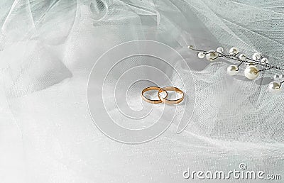 Flat lay background with a pair of gold rings and pearl necklace for wedding or engagement decorated with white lace of a veil of Stock Photo