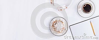 Flat lay of Belgian waffles with marshmallows and coffee, headphones and empty notebook on white background. Top view. Minimal Stock Photo