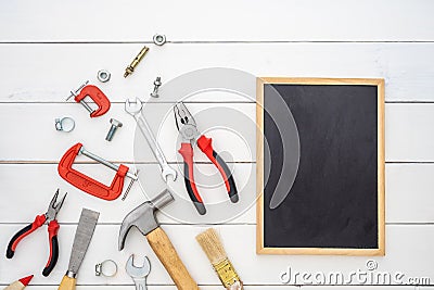 Flat lay of blank space blackboard with construction handy tools over wooden background. Top view with copy space for your Stock Photo