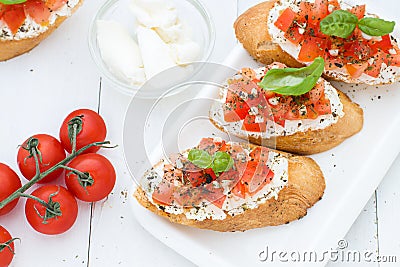 Flat lay with bruschettas with cream cheese, tomatoes and basil. Top view Stock Photo