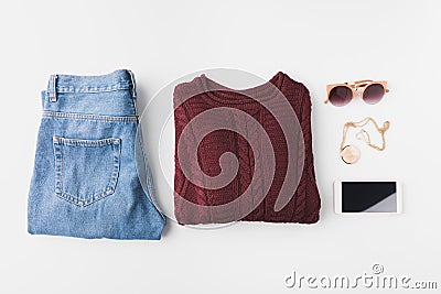 flat lay with burgundy knitted sweater, trendy jeans, accessories and smartphone, Stock Photo