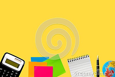 Flat lay of business concept. Calculator, sticky notes, notepad, fountain pen and world globe on yellow background Stock Photo