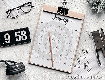 Flat lay of a calendar diary, flip clock screensaver on the phone, glasses, clips, and pencil Stock Photo