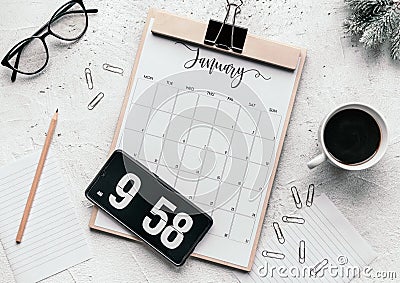 Flat lay of a calendar diary, flip clock screensaver on the phone, mug, glasses, clips, and pencil Stock Photo