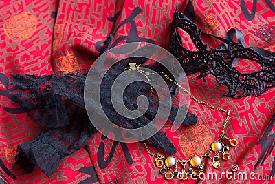 Flat lay carnival themed photo of pretty short lace gloves, domino mask, and costume jewelry necklace Stock Photo