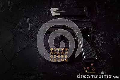 Flat lay of cartridges and gun on concrete background. Stock Photo