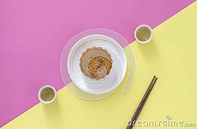 Flat lay of Chinese Festival dessert, Mid- Autumn Festival Moon cake on colorful background with teas and chopsticks. Stock Photo