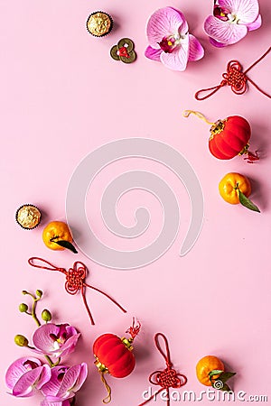 Flat lay of Chinese new year table set with oranges, golden sweets and flowers Stock Photo