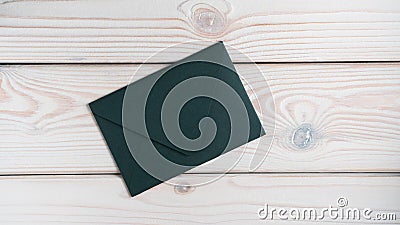Flat lay of closed sealed green emerald envelope on grey wooden table. Correspondence, mailing, post office, stationary. Stock Photo