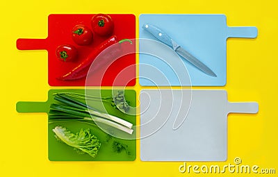 Flat lay of colored cutting boards with green fresh vegetable , fresh tomatoes and red bell pepper kapia colorful minimalist food Stock Photo