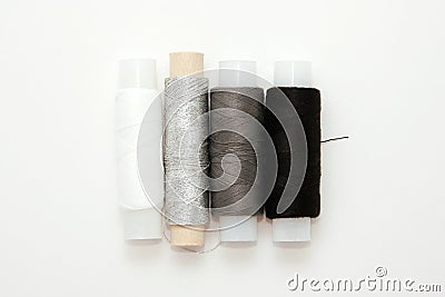 Flat lay colorful cotton thread spools, embroidery white, gray, black, silver, bobbins, mock up, top view. Layout mockup blank Stock Photo