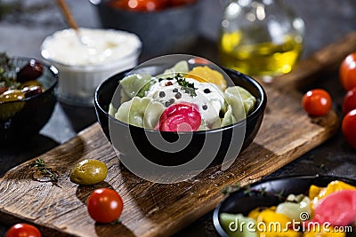 Flat lay composition of bowl of dumplings, jar of sour cream on wooden board Stock Photo