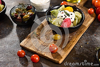 Flat lay composition of bowl of dumplings, jar of sour cream on wooden board Stock Photo