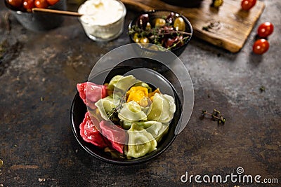 Flat lay composition of bowl of dumplings, jar of sour cream on wooden board Stock Photo