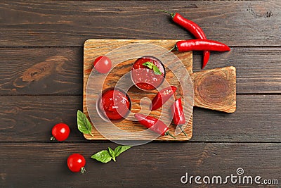 Flat lay composition with bowls of spicy chili sauce and cutting board Stock Photo