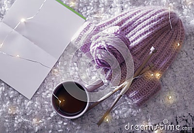 Flat lay composition with cup of hot beverage, knitting yarn and book on fuzzy rug Stock Photo