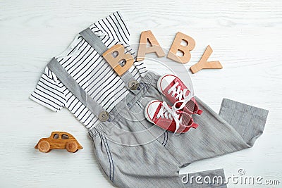 Flat lay composition with cute clothes on white wooden background. Stock Photo