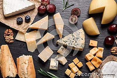 Flat lay composition with different types of delicious cheese on slate Stock Photo