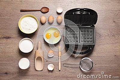 Flat lay composition with ingredients and Belgian waffle maker on table Stock Photo